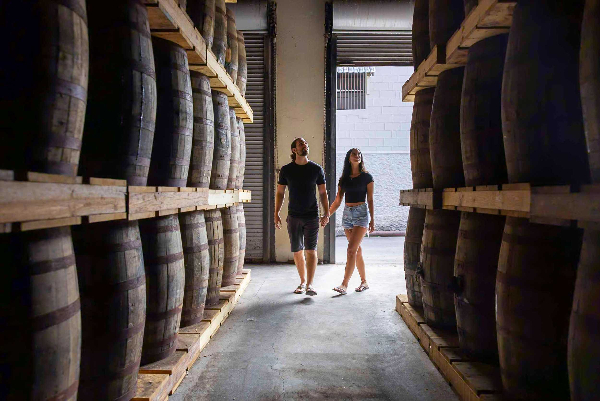 Visitors enjoying a guided tour inside the St Vincent Distillers with copper stills and barrels